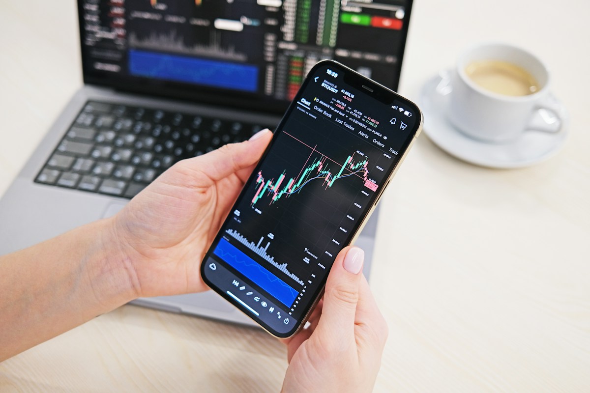 Trader checking live charts on a mobile trading app